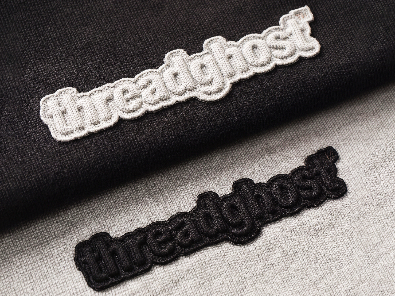 Two threadghost appliqué patches, white on black and black on grey