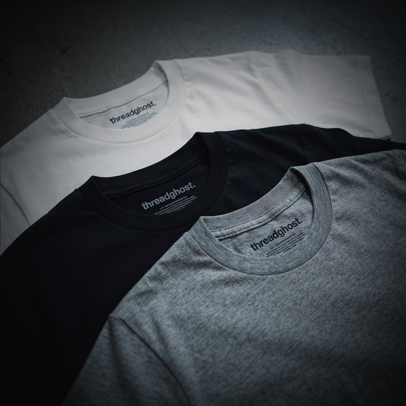 Kids' tees in white, black and grey, stacked flat