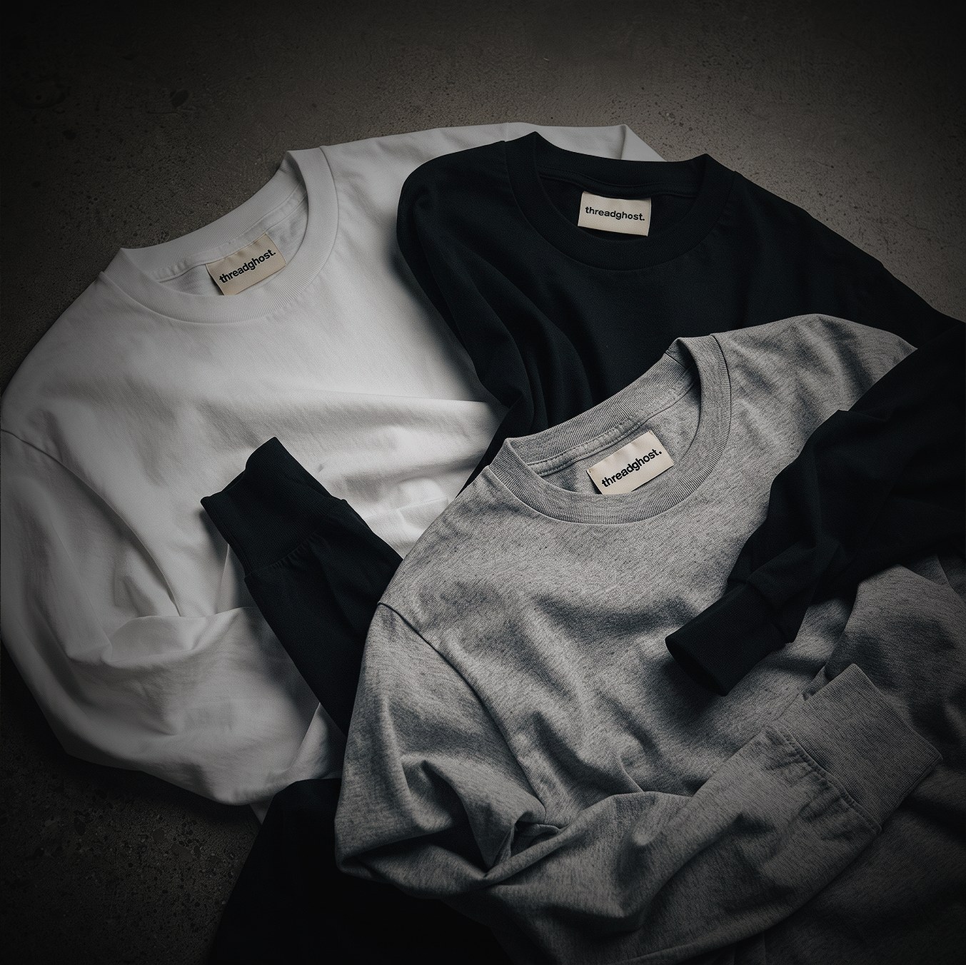 Folded black, white and grey threadghost long sleeve tees