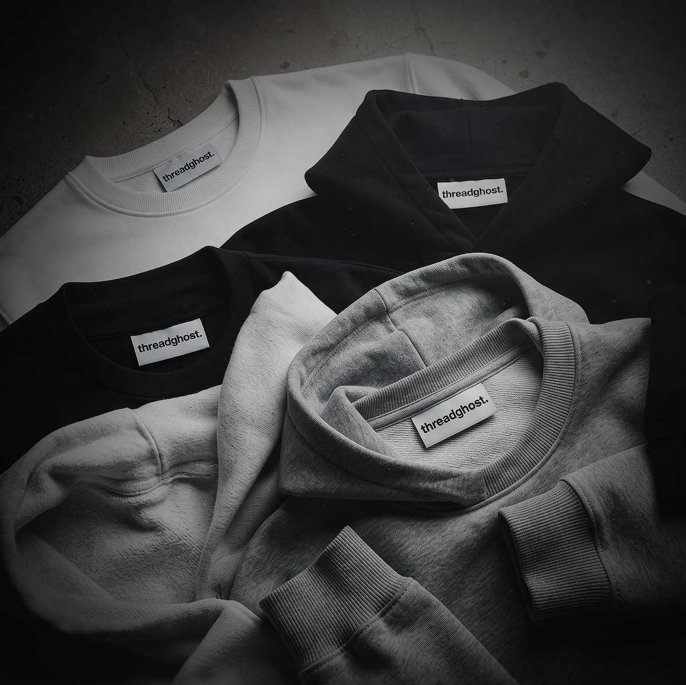 Grey, white and black threadghost sweatshirts in a pile
